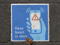 908191 Afbeelding van een tegel met de tekst: 'Deze buurt is alert' in het plaveisel bij de Abel Tasmanbrug te Utrecht.